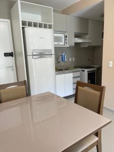 a kitchen with a white refrigerator and a table at VG FUN 308 Praia do Futuro in Fortaleza