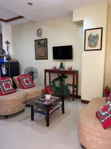 a living room with two couches and a tv at S&E Apartment unit, Lapaz, Iloilo city in Iloilo City