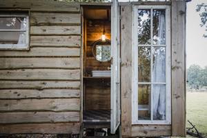 Zoersel的住宿－Ferme NeElke Pipowagens，享有带窗户的木屋外的景致。