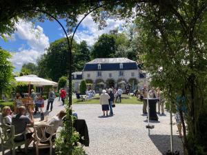 a group of people sitting at tables in front of a building at Green Escape Durbuy in Durbuy