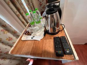 een tafel met een koffiepot en twee afstandsbedieningen bij MR Hotel Nusa Bestari in Skudai