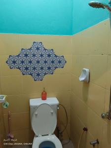 een badkamer met een toilet met een bloemenpatroon op de muur bij EMBUN 2 LANGKAWI HOMESTAY in Pantai Cenang