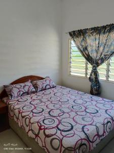 een slaapkamer met een bed en een raam bij EMBUN 2 LANGKAWI HOMESTAY in Pantai Cenang