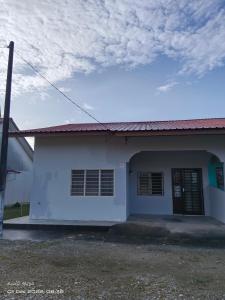 een wit huis met een blauwe lucht en wolken bij EMBUN 2 LANGKAWI HOMESTAY in Pantai Cenang