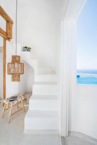 a white staircase in a room with a table and a window at Sophia Boutique Hotel in Oia