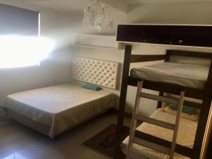 Habitación con 2 literas y lámpara de araña. en Villa das Flores - aptos 2 e 9, en Pinheira 46 fotos más