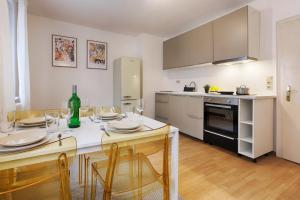 una cocina con mesa y sillas y una cocina con mesa y sillón. en Central, modern city apartments - by homekeepers, en Würzburg