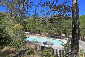 a swimming pool in a yard with a fence at Huttopia Gorges du Verdon in Castellane