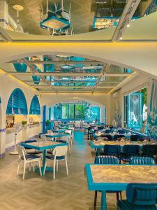 SUNTORINI BOUTIQUE HOTEL في فنغ تاو: غرفة طعام مع طاولات وكراسي ونوافذ
