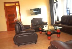 - un salon avec des fauteuils en cuir et une table dans l'établissement Sunny Hill Apartments, à Kigali