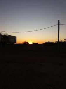 una puesta de sol en un campo con un poste de teléfono en Aroma de mar, en Sauce de Portezuelo