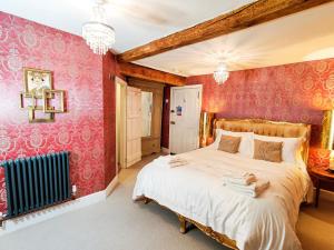 a bedroom with a large bed with pink walls at Plas Dolguog in Machynlleth