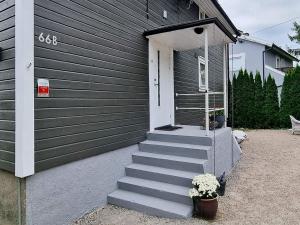 ein Haus mit einer Treppe, die zu einer Tür mit Blumen führt in der Unterkunft Apartment Frederikstad in Fredrikstad