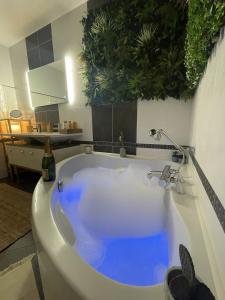 - białą wannę z niebieską wodą w łazience w obiekcie Cosy et jardin panoramique w mieście Morlaix