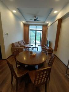 The Retreat Sweety 3BR H/Stay في برينشانغ: غرفة معيشة مع طاولة وكراسي خشبية