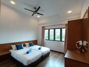 a bedroom with two beds and a ceiling fan at The Retreat Sweety 3BR H/Stay in Brinchang