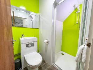 a bathroom with a toilet and a green wall at Baxter House in Boston