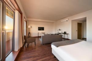 une chambre d'hôtel avec un lit et un canapé dans l'établissement Exe Praia Golfe, à Espinho
