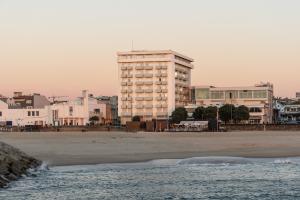 a large building on the beach with the ocean at Exe Praia Golfe in Espinho