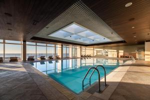 a large swimming pool with a large glass wall at Exe Praia Golfe in Espinho