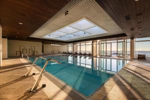 a swimming pool in a building with a large window at Exe Praia Golfe in Espinho