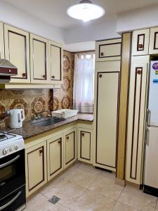 a kitchen with white cabinets and a sink and a refrigerator at DEPTARTAMENTO Mar Del Plata 3 Dormitorios in Mar del Plata