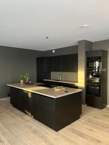 a kitchen with black cabinets and a kitchen island at Trysil Alpine Lodge in Trysil