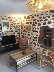 Televízia a/alebo spoločenská miestnosť v ubytovaní Maison auvergnate traditionnelle récemment rénovée + 20 fotografií