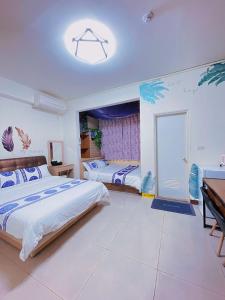 1 dormitorio con 2 camas y mesa en 親愛的民宿 en Jinning