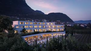 a large white building with mountains in the background at Villa Weingarten in Caldaro