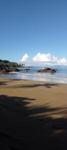 uma praia com areia preta e o oceano em Cabins yafeth osa drake bay em Drake