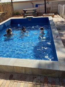 three children swimming in a swimming pool at Uitzicht in Beaufort West