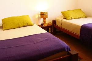 1 dormitorio con 2 camas con sábanas amarillas y moradas en Casa Suyay en Tilcara