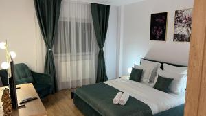 une chambre d'hôtel avec un lit et une chaise dans l'établissement Aparthotel Junior4 Cluj, à Cluj-Napoca