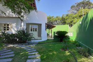 Un patio trasero con una casa verde y blanca. en VILLA RANIERI, en Pipa