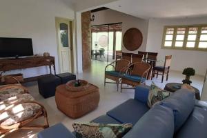 Una sala de estar con un sofá azul y sillas. en VILLA RANIERI, en Pipa