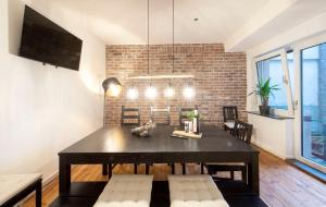 a dining room with a table and a brick wall at Cozy Apartment ° 7 beds ° 3 bed rooms in Kleve