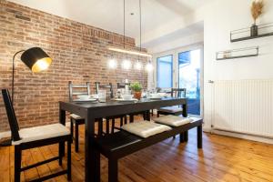 une salle à manger avec un mur en briques, une table et des chaises dans l'établissement Cozy Apartment ° 7 beds ° 3 bed rooms, à Clèves