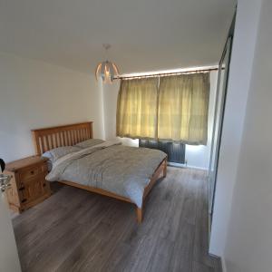 um quarto com uma cama e uma janela em Lovely Home away from home! em Bexleyheath