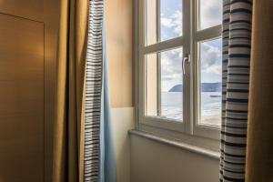 ein Fenster in einem Zimmer mit Meerblick in der Unterkunft Grand Hotel Alassio Beach & Spa Resort - The Leading Hotels of the World in Alassio