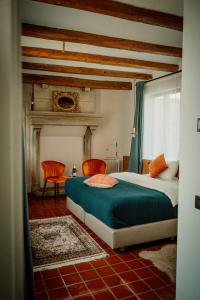 - une chambre avec un lit et deux chaises dans l'établissement Relais M B&B, à Frasnes-lez-Anvaing