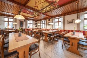 ein leeres Restaurant mit Holztischen und -stühlen in der Unterkunft Landhotel Gasthof Stern in Gößweinstein