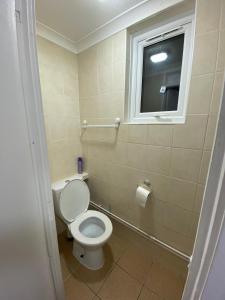 a bathroom with a white toilet and a window at Home away from home with fantastic spacious rooms in Abbey Wood