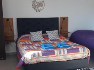 a bedroom with a large bed with blue towels on it at Gemas Apart in Villa Yacanto +19 photos