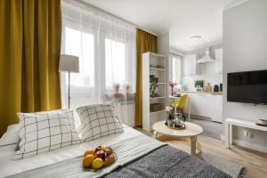 uma sala de estar com uma cama com fruta em Apartments Centre by Arrenda em Varsóvia