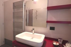 Un baño con un lavabo blanco y un espejo. en Palazzo del Duca, en Verona