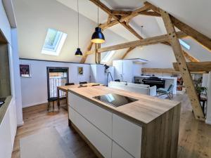 eine Küche mit einer Insel in einem Zimmer mit Holzbalken in der Unterkunft Maison de Village 296-4 in Duingt