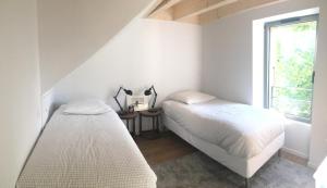 2 Betten in einem Zimmer mit Fenster in der Unterkunft Maison de Village 296-4 in Duingt