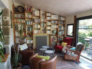 Ty Joé, grande et belle maison de caractère في سارزو: غرفة معيشة مع رف للكتب مليئ بالكتب