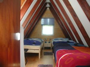 Gossersweiler-SteinにあるFerienhaus-Rosensteig-128-im-Feriendorf-Eichwaldの屋根裏にあるベッドが2つある寝室